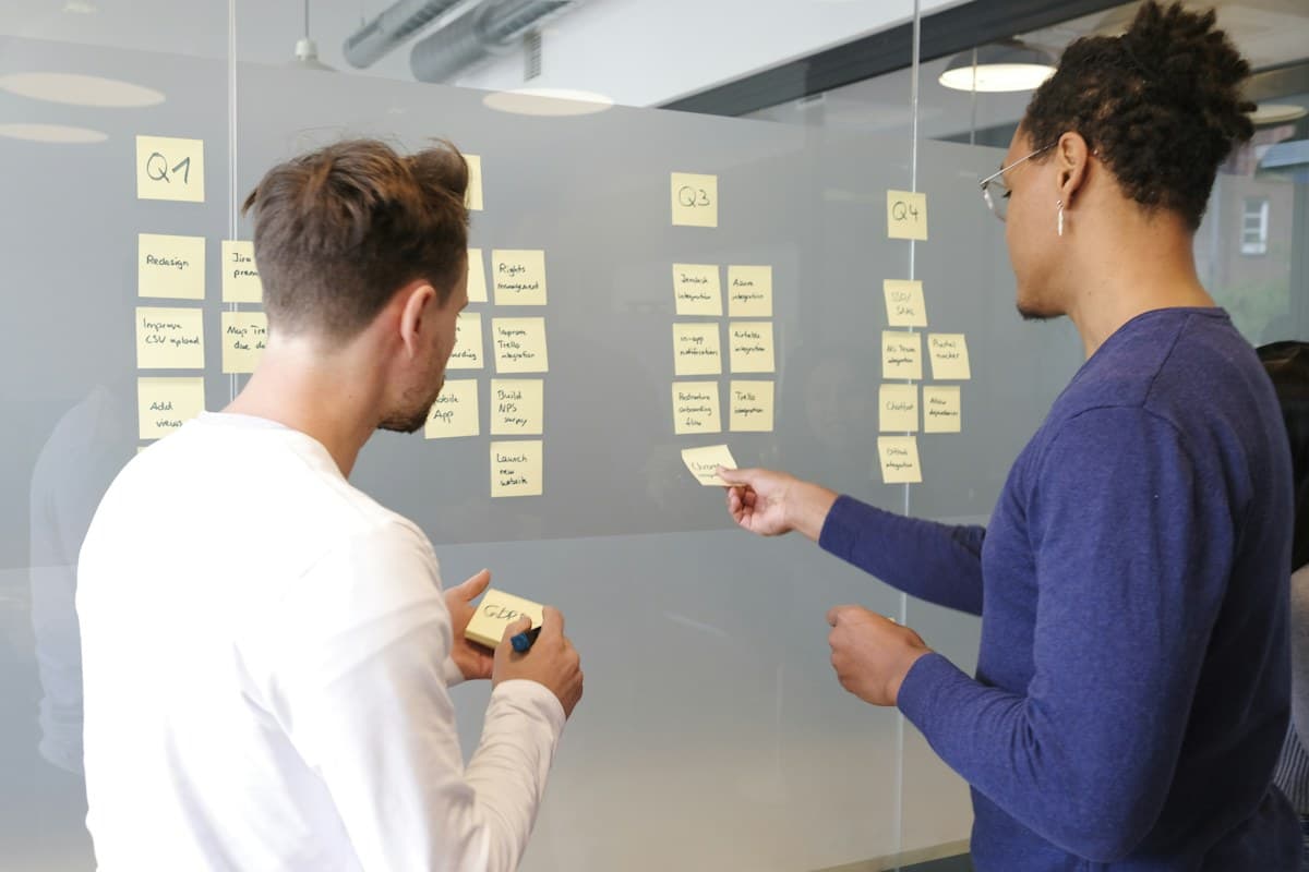 Deux professionnels organisent un plan de travail sur un tableau