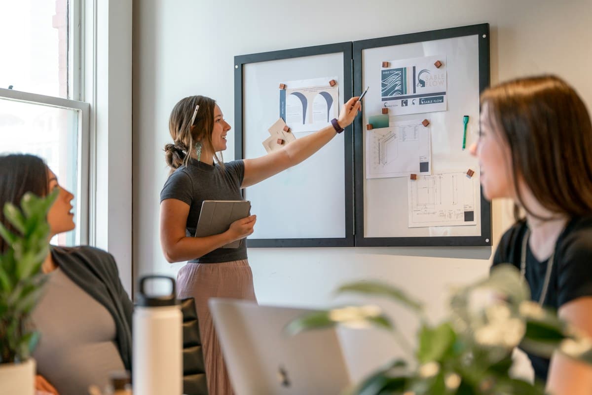Une équipe de petite entreprise travaille autour d’un tableau de suivi